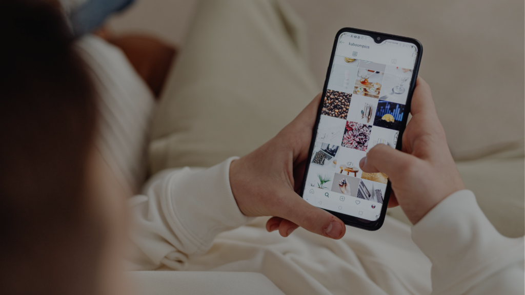 Mains tenant un smartphone affichant un fil Instagram
