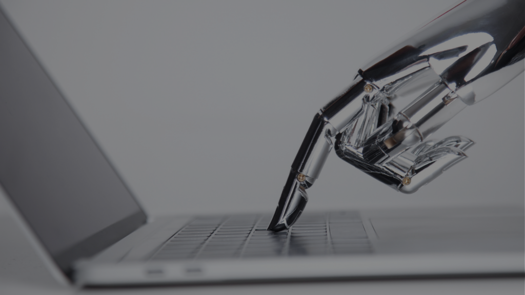 Main robotique posée sur le clavier d'un ordinateur portable